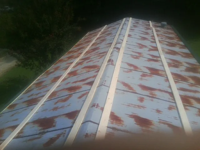 Rusted metal roof panels with new wood purlins before replacement — Storm Damage Roof Repair in Mc Grady by Roofing Brothers