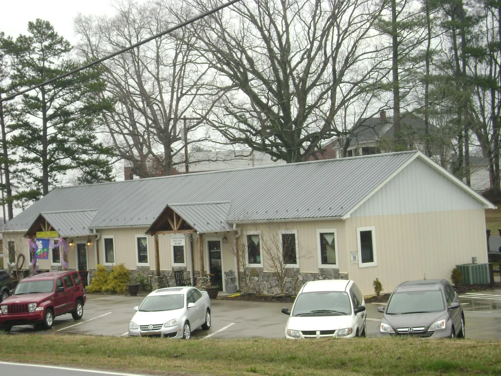 Gray metal roof with timber entry brackets on a small commercial building in Mc Grady