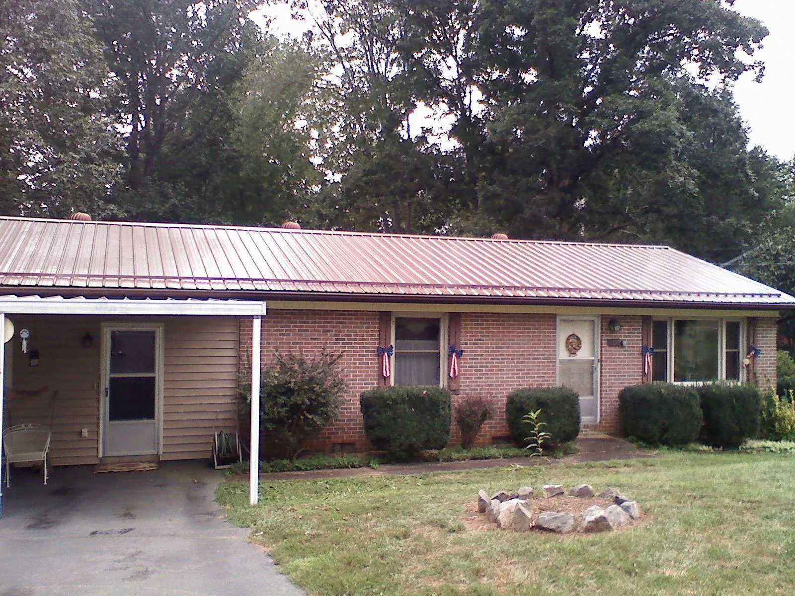 Bronze metal roof and carport on a brick ranch home — Roof Repair work by our crew in Mc Grady